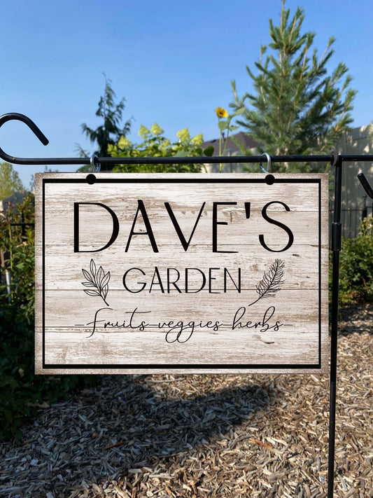 Garden sign with 'Dave's Garden' text in a natural setting